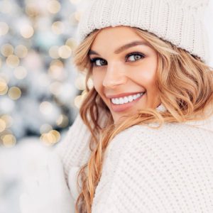 Beautiful girl sitting near New Year tree